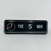 Retro black analog clock with clock face and vintage mechanical flip date, mid-century modern desk or wall clock