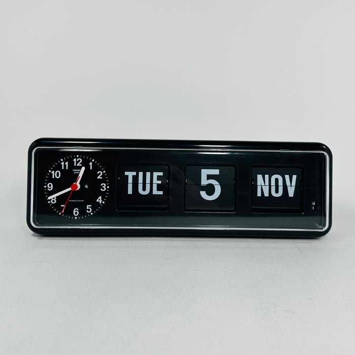 Retro black analog clock with clock face and vintage mechanical flip date, mid-century modern desk or wall clock