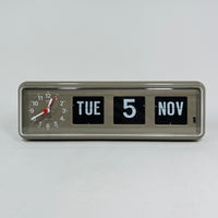 Retro grey analog flip clock with clock face and vintage mechanical flip date, mid-century modern desk or wall clock