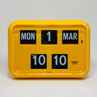 Retro yellow analog flip clock with perpetual calendar, vintage mechanical flip display, mid-century modern desk or wall clock