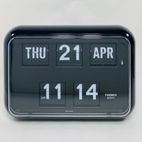 Retro black analog flip clock with perpetual calendar, vintage mechanical flip display, mid-century modern desk or wall clock