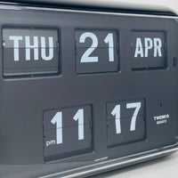 Retro black analog flip clock with perpetual calendar, vintage mechanical flip display, mid-century modern desk or wall clock
