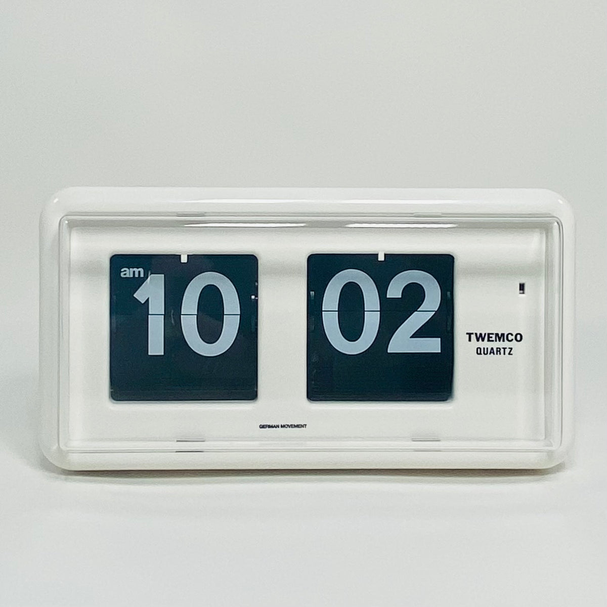 Retro white analog flip clock, vintage mechanical flip display, mid-century modern desk or wall clock